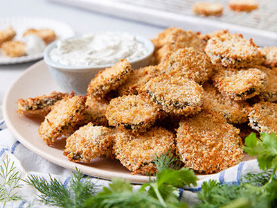fried pickles on a plate with homemade ranch on side